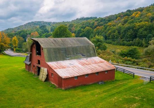 Red barn next to an empty road