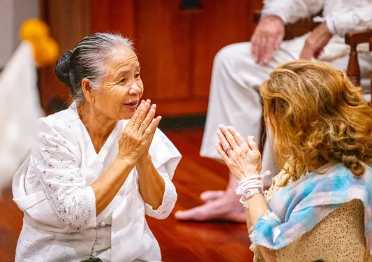 Two women bow to each other