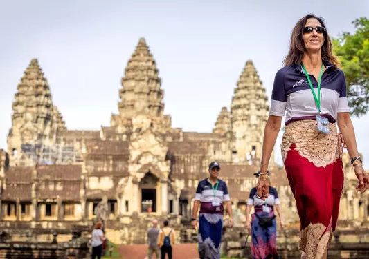 people in traditional clothing walk through a temple