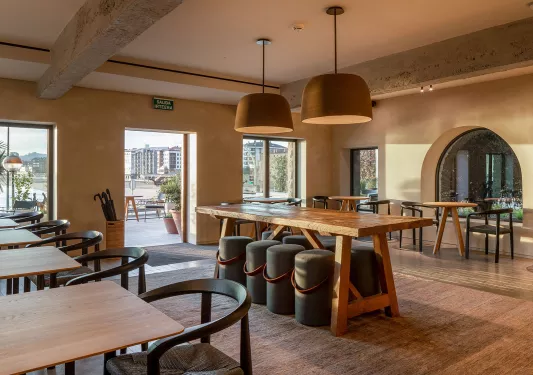 Indoor dining area with wooden furniture and a large open door leading to an outdoor patio