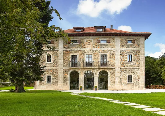 Exterior view of stone building with 3 large archways and small balconies above