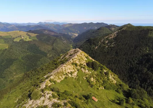 Grassy hill in the middle of an open valley of other hills