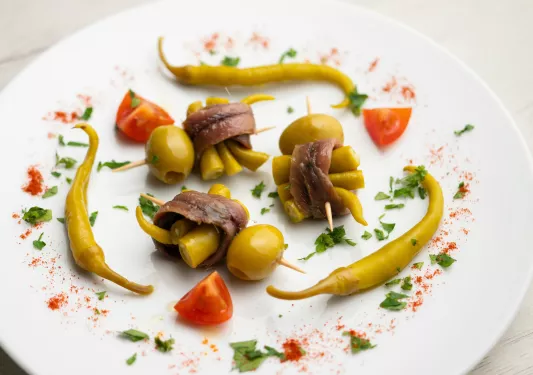 Fancy assortment plate with chilis, olives, and anchovy-wrapped chilis