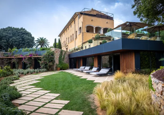 hotel with lots of outdoor seating and manicured gardens