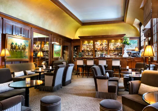 Indoor bar and lounge with black and white cushioned chairs and wooden walls
