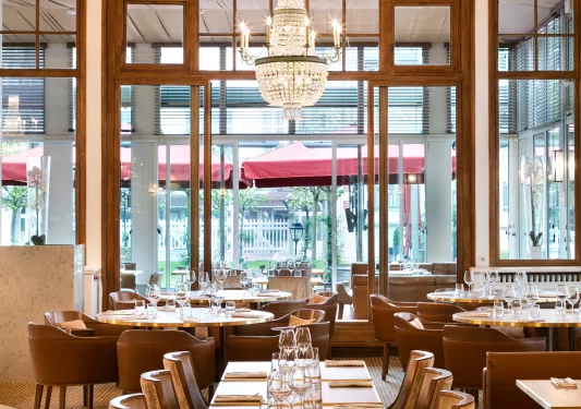 Indoor dining area with leather seats and wine glasses on each table