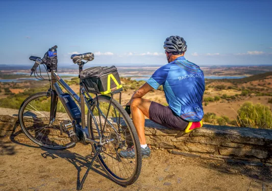A biker with an electric bike looking towards the hills