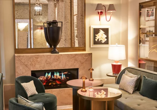 Indoor lounge with a fireplace and a vase on top