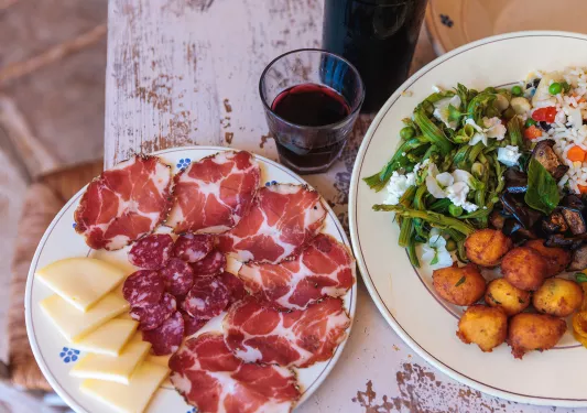 Plates full of cured meats, cheeses and salad