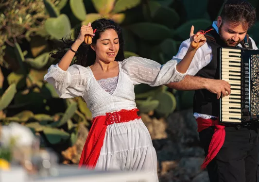 Woman dancing while man playing the accordion