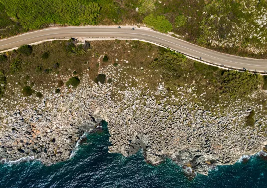 Aerial view of a rocky coastline next to blue water