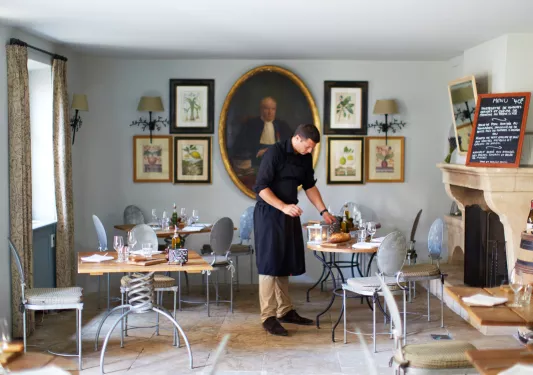 waiter setting table in dining room