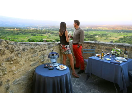 two people having drinks on a balcony