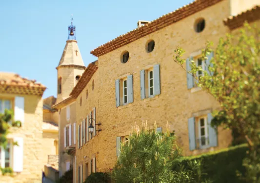 side of a yellow building with blue shutters