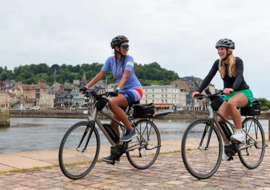 cyclists ride by river