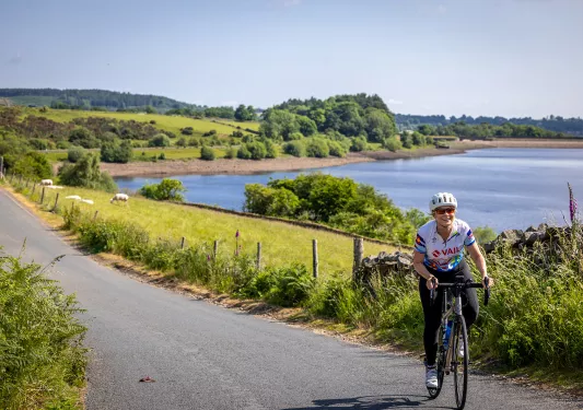 person biking past lake