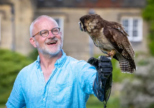 a man holding an owl