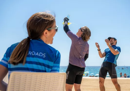 Woman drinking from a glass while a man is laughing and clapping