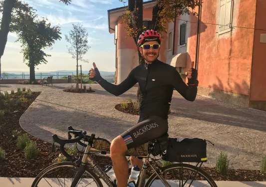 Man on a bike with both thumbs up