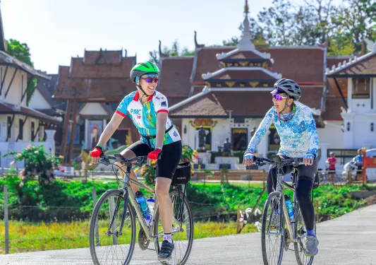 Two people biking through town
