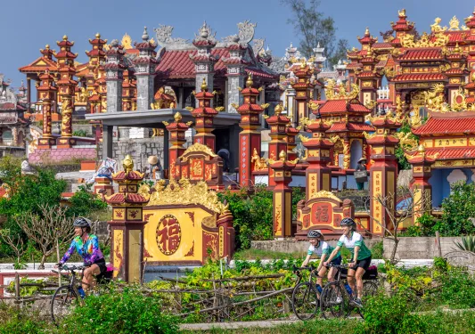 Bikers cycling through red and yellow temples