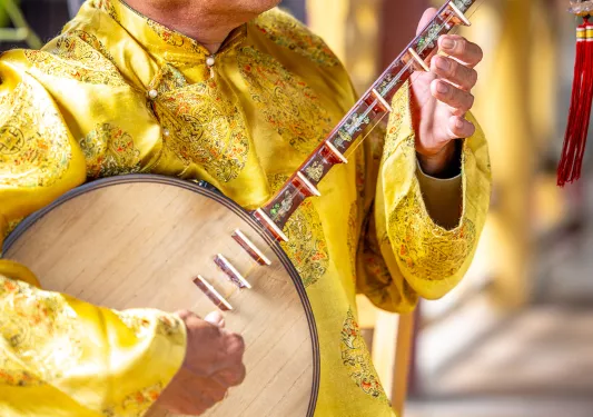 Person in yellow uniform playing instrument