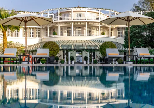 Exterior, wide view of white, castle-like building with balconies and an outdoor pool