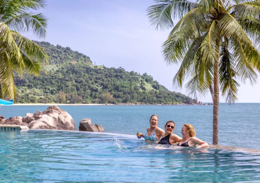 people lounge in a beach front pool