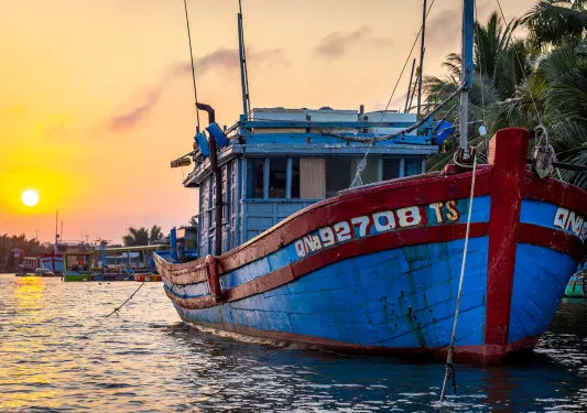 A boat in the water during sunset