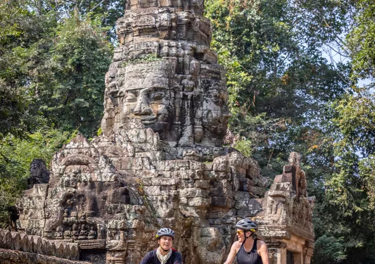 Bike riders in front of stone statue