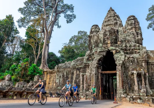 people bike through a covered bridge