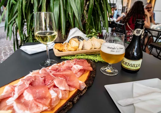 Two wooden planks full of cured meat and bread