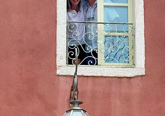 Man and woman smiling through a small window