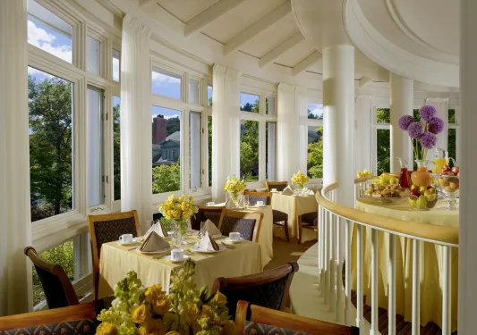 Circular room and dining area, with yellow tables and wooden chairs