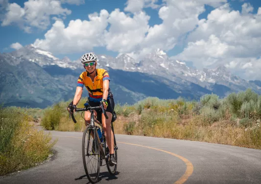 Woman biking among the Tetons