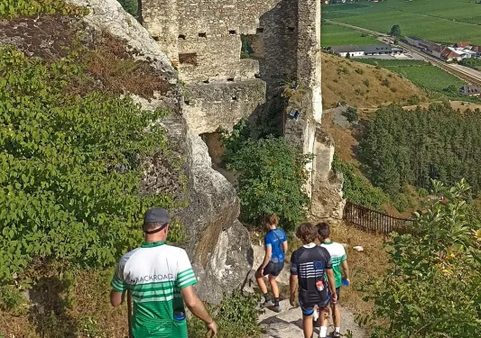 Group of people walking down a stone path of rundown ruins