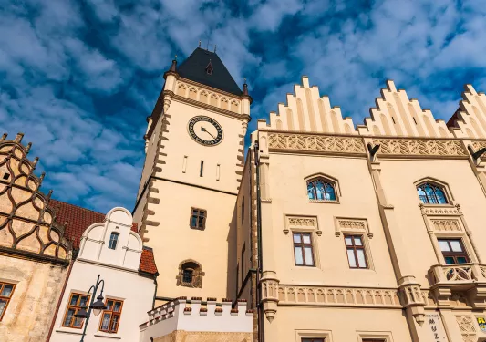 Concrete brown clocktower under a blue sky