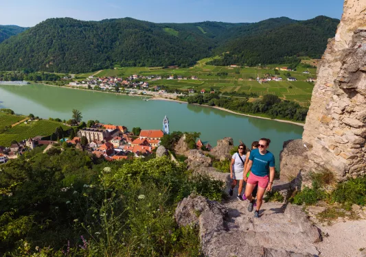 Three women hiking cliffside overlooking the water