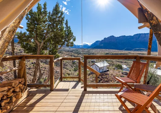 Wooden patio of a luxury hut, with a large valley in the background