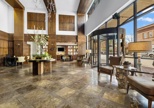 Indoor lobby view with a glass wall and rotating door leading to the outdoors