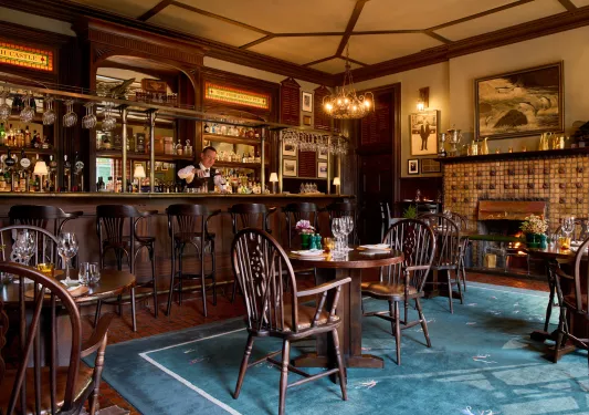 bartender behind the bar of dark wood