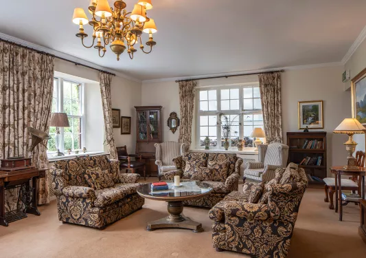 Indoor library with black and orange sofas and paintings on the wall