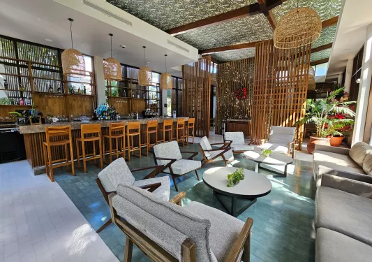 Indoor lobby with chairs and a bar island with stools