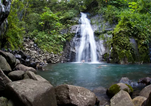 Group of people under a waterfall in a lake