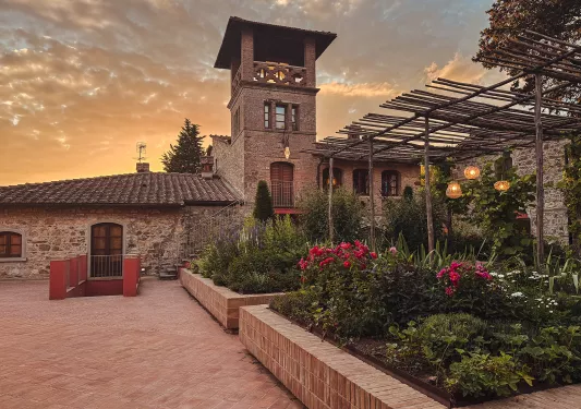 Stone building with an outdoor courtyard, filled with plants and lanterns