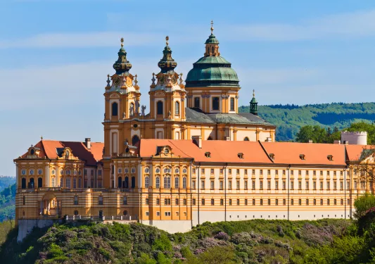 White and tan castle-like building with a church in the center