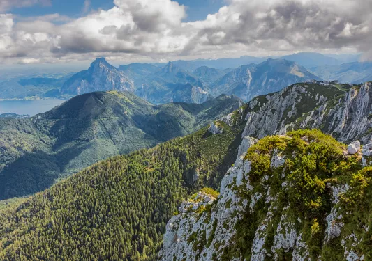 Large mountains and grassy hills with cloudy skies above