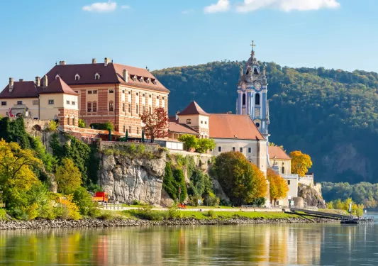 Large buildings on a small cliff overlooking a port