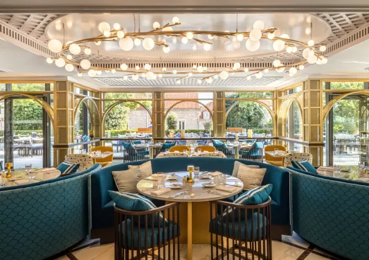 dining room with blue seating and large chandelier