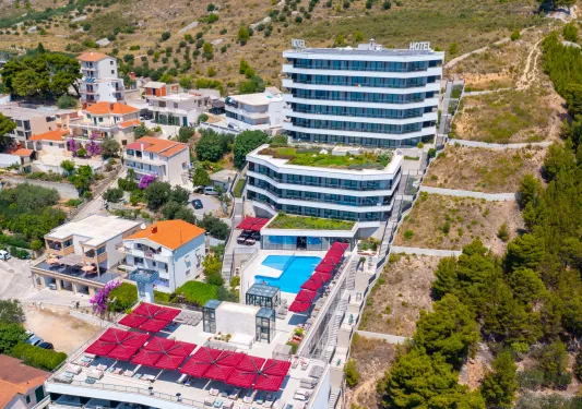 Exterior view of hotel building with large, glass patios on a hill